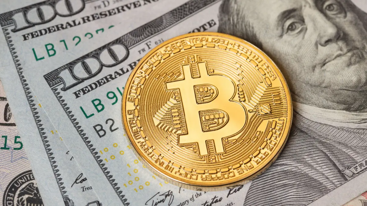 Een afbeelding van een bitcoin (BTC) munt op Amerikaans briefgeld Een afbeelding van een bitcoin (BTC) munt op Amerikaans briefgeld